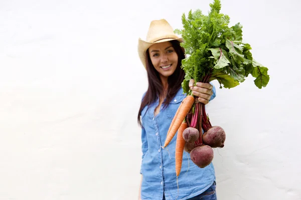 Улыбающаяся женщина с морковью и свеклой — стоковое фото