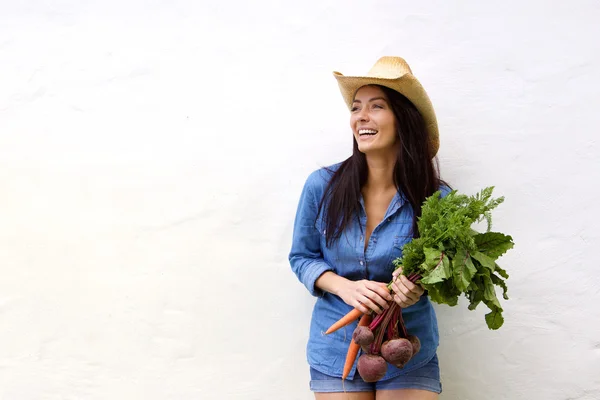 Laughing woman holding bunch of vegetables in hands — Stock Photo, Image