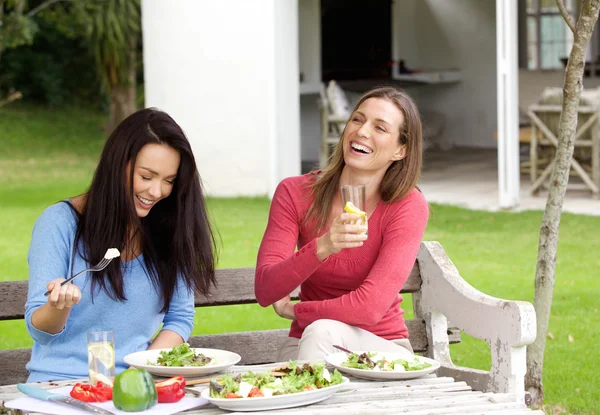 Dos amigas riendo y almorzando juntas — Foto de Stock