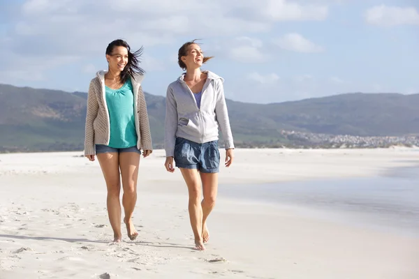 Duas mulheres sorridentes amigas andando na praia juntas — Fotografia de Stock