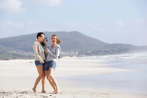 Dos amigas riéndose en la playa — Foto de Stock