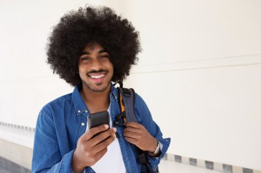 Cep telefonu ile yürüyen siyah adam gülümseyen