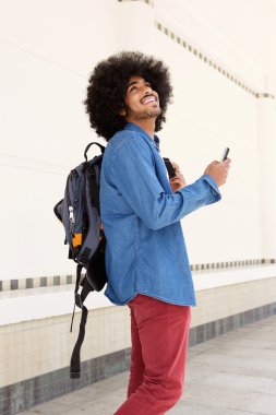 Mutlu adam çanta ve cep telefonu ile yürüyor