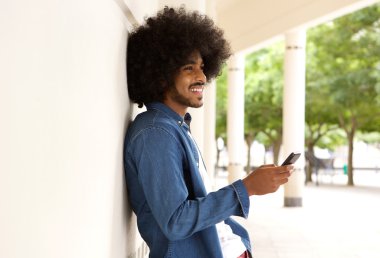 Modern insan ayakta dışında cep telefonu ile gülümseyen