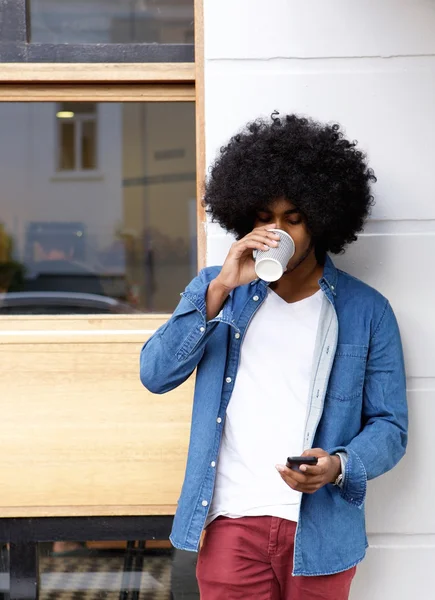 Fajny facet, picia kawy i przy użyciu telefonów komórkowych — Zdjęcie stockowe