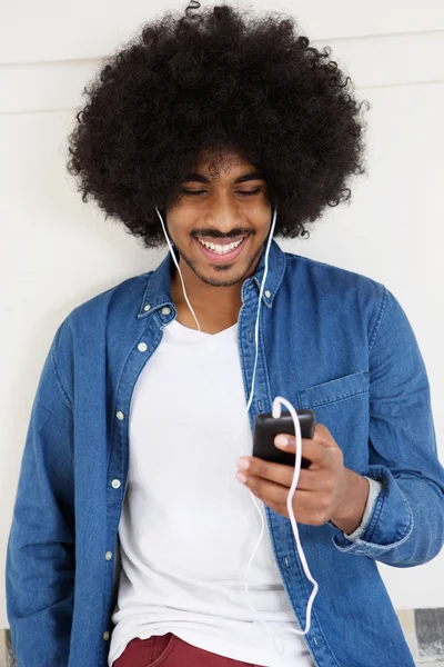 Fajny facet uśmiechający się z telefonu komórkowego i słuchawki — Zdjęcie stockowe