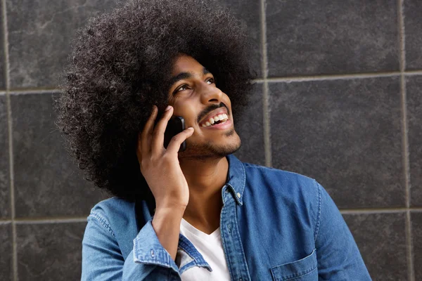 Glücklicher schwarzer Kerl, der auf Handy spricht — Stockfoto