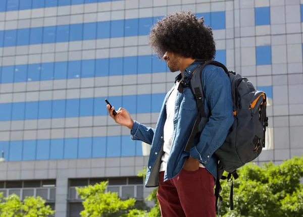 Giovane che cammina in città con il cellulare — Foto Stock