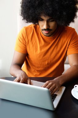 Dizüstü bilgisayar kullanan genç siyah adam