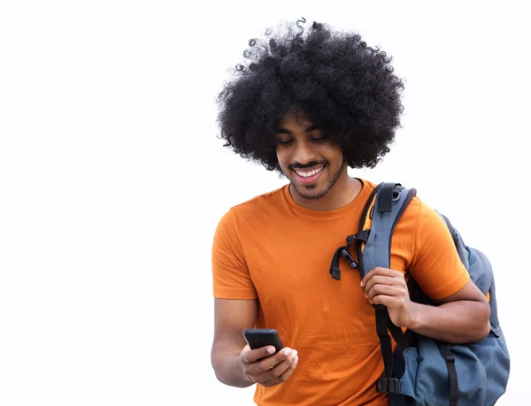Крутой молодой человек с сумкой смотрит на мобильный телефон — стоковое фото