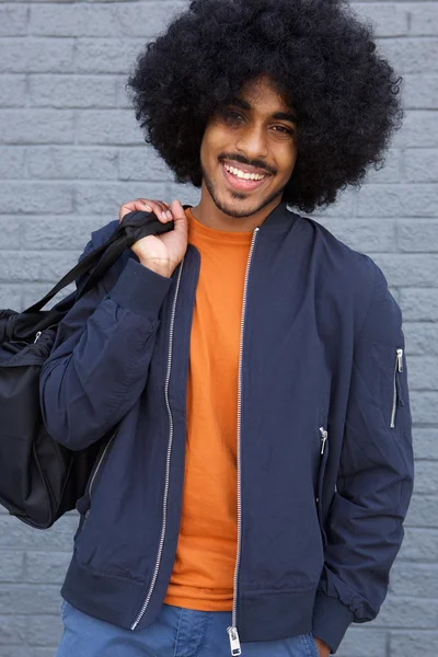 Smiling black guy with afro holding  bag — Stock Photo, Image