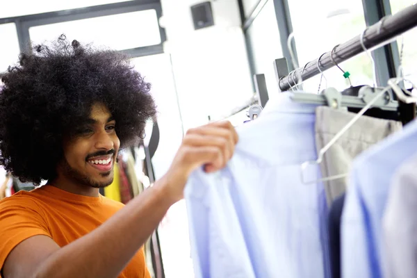 Hombre mirando ropa en la tienda —  Fotos de Stock