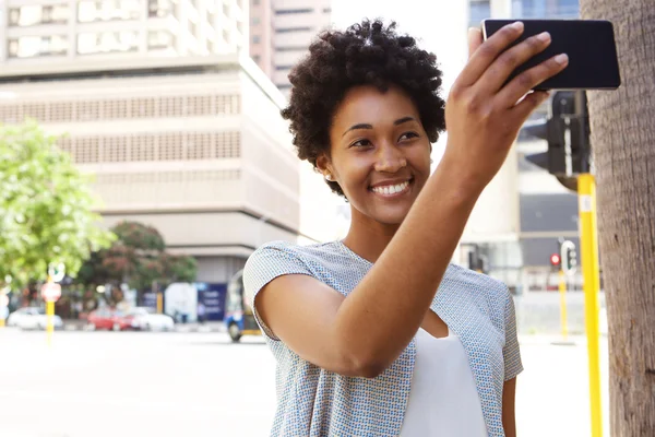 Heureuse femme africaine prenant un selfie — Photo