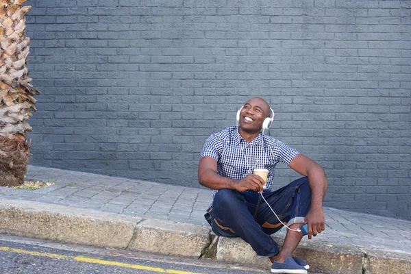 Lycklig man sitter vid en gata — Stockfoto