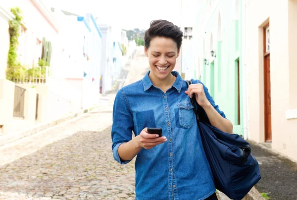 携帯電話と一緒に歩いている幸せな若い女性 — ストック写真