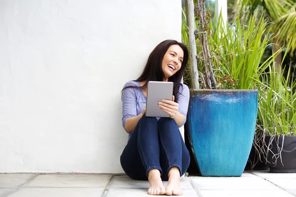 Smiling woman sitting in patio — Stock Photo, Image