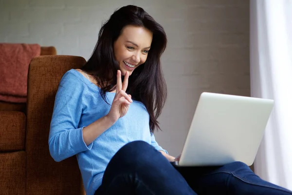 Sonriente joven femanmaking videollamada utilizando el ordenador portátil —  Fotos de Stock
