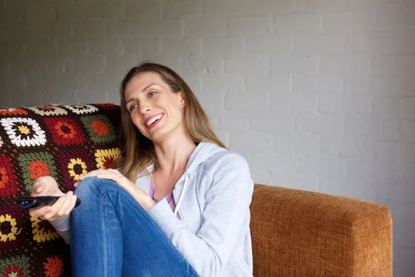 Mujer sonriente con control remoto —  Fotos de Stock