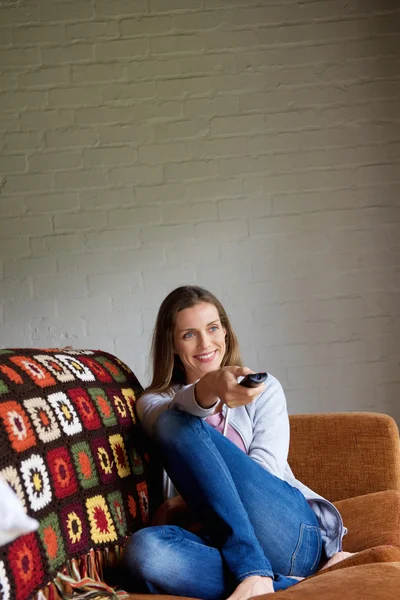 Smiling woman with remote control — Stock Photo, Image