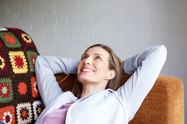 Femme souriante se détendre à la maison canapé — Photo