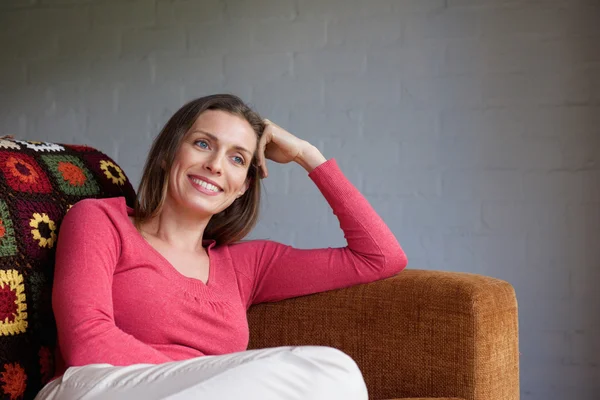 Усміхнена жінка розслабляється на дивані — стокове фото