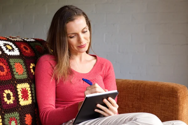 Ältere Frau macht sich Notizen — Stockfoto