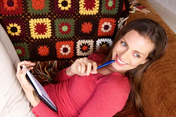 Uśmiechnięta kobieta relaksujący na kanapie — Zdjęcie stockowe