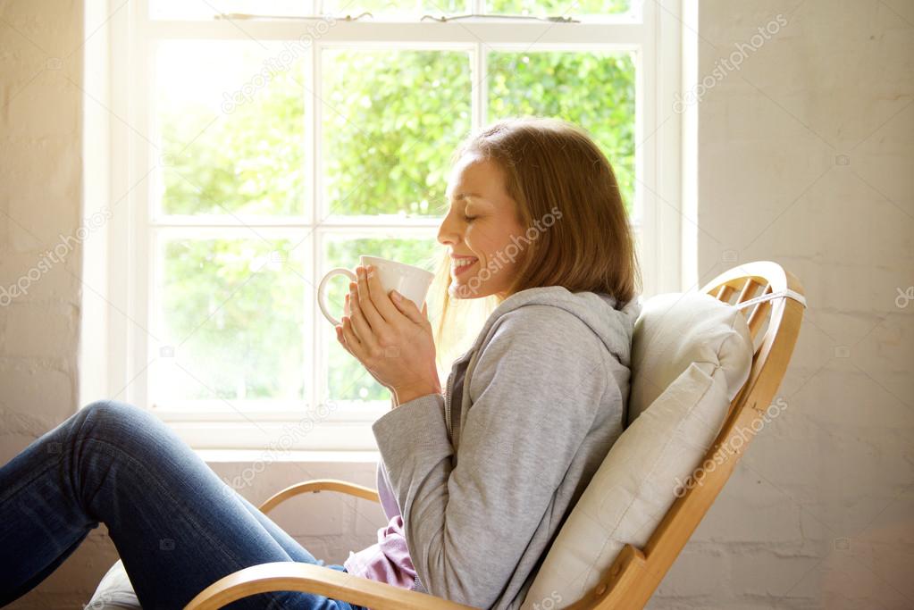 woman keeping warm with cup of tea