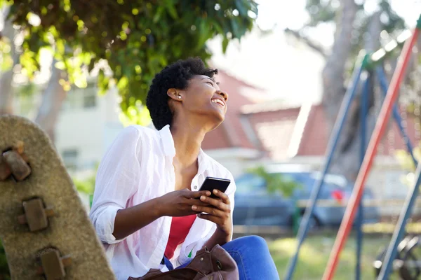 Mujer alegre sentada en un banco del parque — Foto de Stock