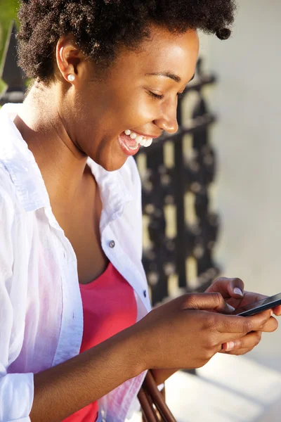 Vrolijke jonge vrouw met behulp van mobiele telefoon — Stockfoto