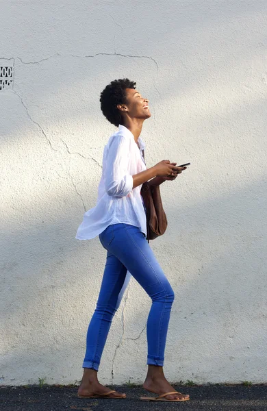 Улыбающаяся чёрная женщина идёт по улице — стоковое фото