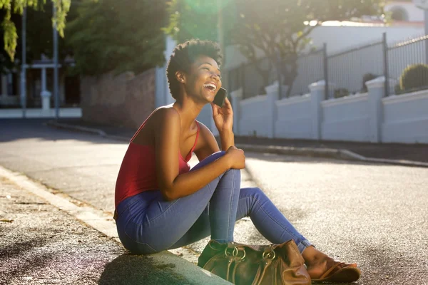 Mujer joven sentada en una calle — Foto de Stock