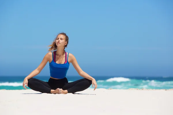 Yoga kvinna sitter på sandstrand — Stockfoto