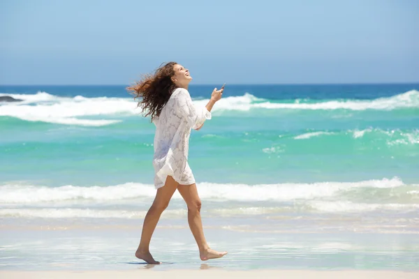 Young woman walking with mobile phone — Stock Photo, Image