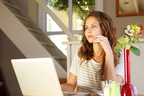 Ung kvinna tänkande med laptop — Stockfoto