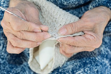Yaşlı crocheting eller