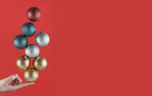 Person Holding One Finger Brightly Colored Christmas Spheres Striking Balance — Stock Photo, Image