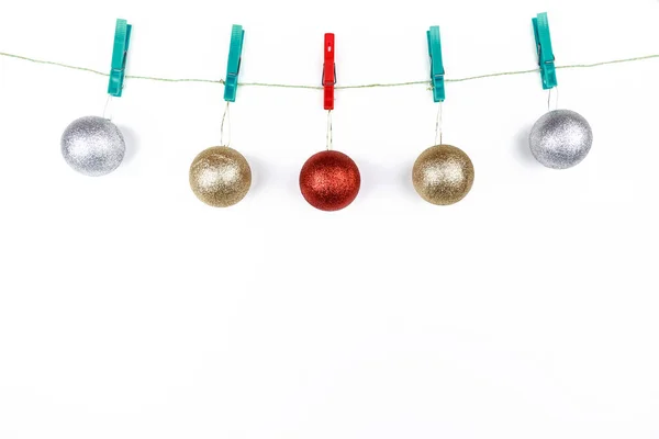 コピースペースと白い背景にロープの上に布のピンが掛けられたクリスマスの球 — ストック写真