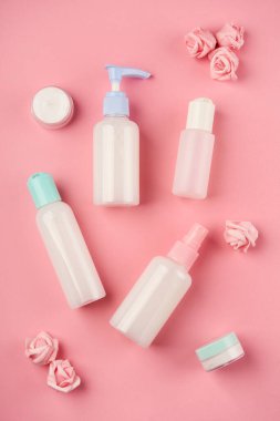 Krem, losyon, jöle, yüz köpüğü ya da pembe arka planda küçük çiçekli cilt bakımı. Kozmetik güzellik ürünü markalaşma modeli