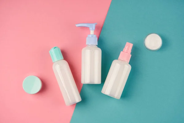 Krem, losyon, jöle, yüz köpüğü ya da mavi ve pembe arka planda cilt bakımı. Kozmetik güzellik ürünü markalaşma modeli. Boşluğu kopyala