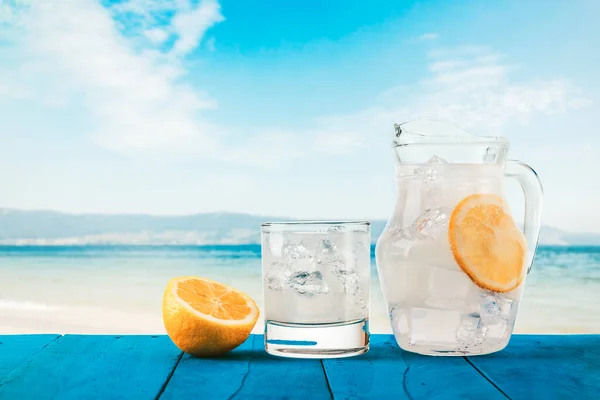 Sıcak bir yaz gününde fotokopi uzayı olan egzotik ve tropik bir plajda mavi bir ahşap masada limonata serinletiyorum.