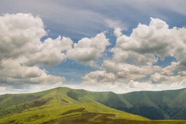 Yeşil dağlar ve mavi bulutlu gökyüzü