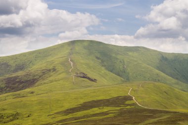 Yeşil dağlar ve mavi bulutlu gökyüzü
