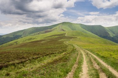 Yeşil dağlar ve mavi bulutlu gökyüzü