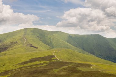 Yeşil dağlar ve mavi bulutlu gökyüzü