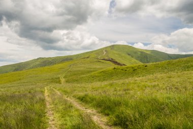 Yeşil dağlar ve mavi bulutlu gökyüzü