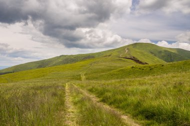 Yeşil dağlar ve mavi bulutlu gökyüzü