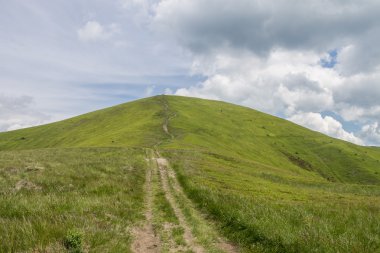 Yeşil dağlar ve mavi bulutlu gökyüzü