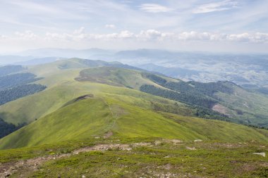 Yeşil dağlar ve mavi bulutlu gökyüzü