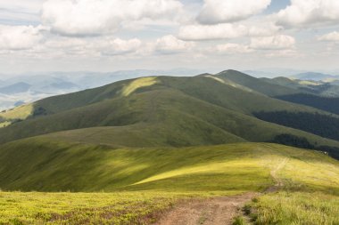 Yeşil dağlar ve mavi bulutlu gökyüzü